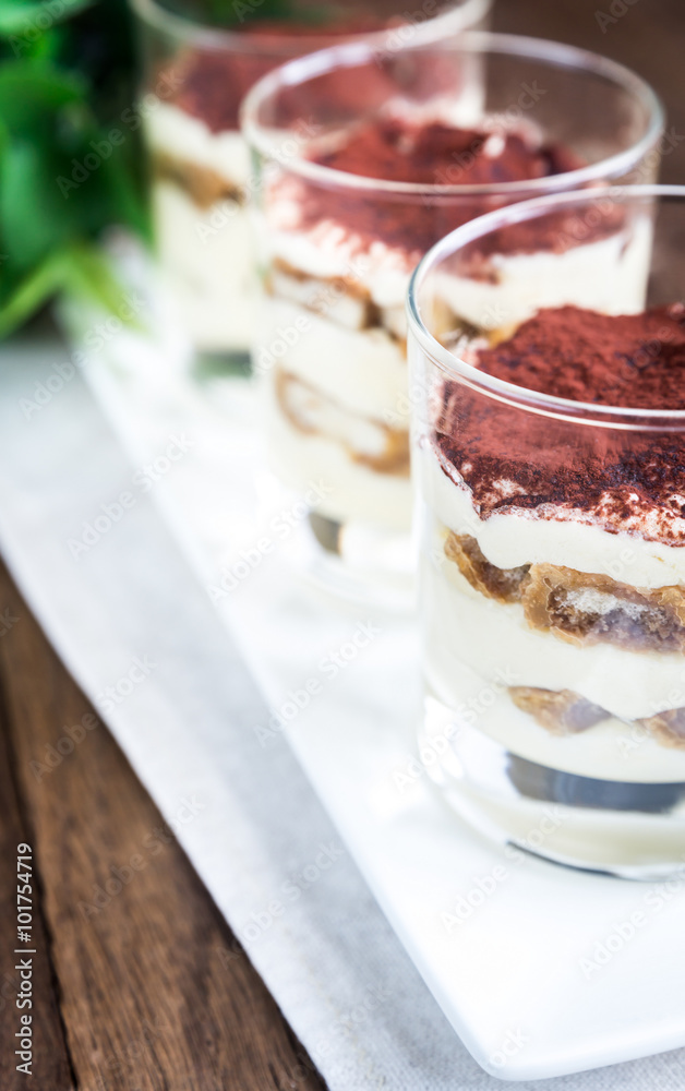 Tiramisu in the glasses on the wooden background Tiramisu in the glasses on the wooden background