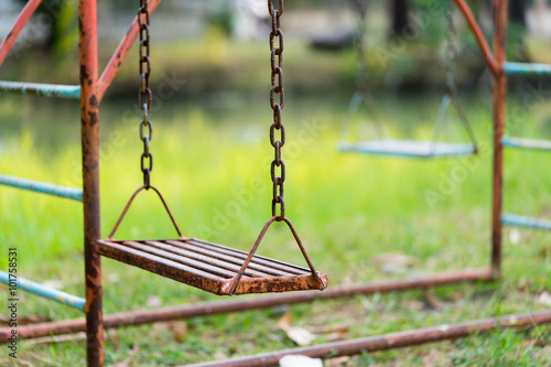 Old rusty playground swing in the park