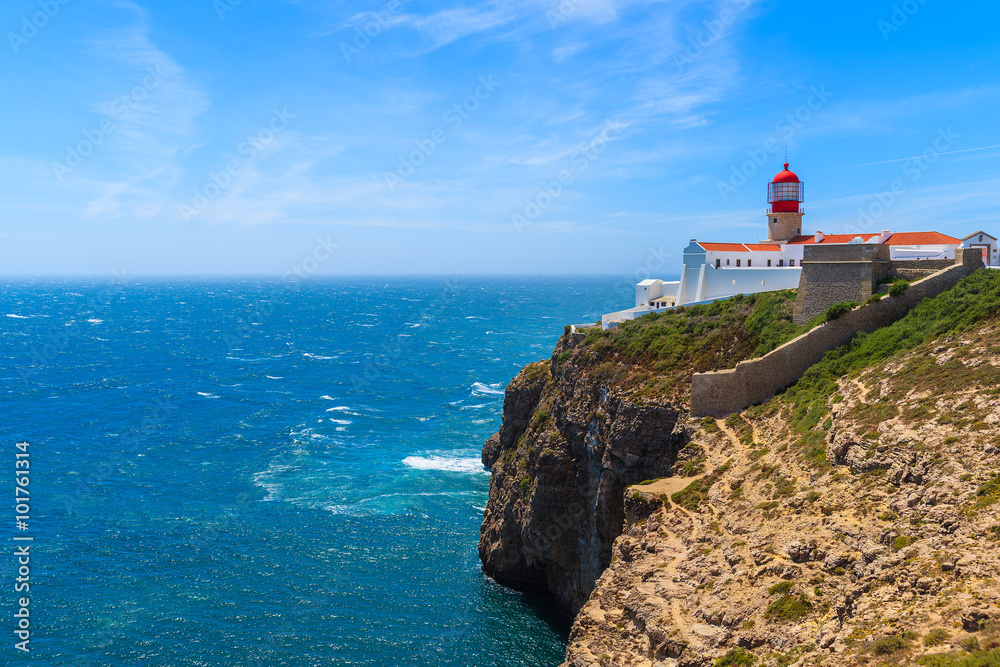 Blue sea and lighthouse on top of cliff at Cabo Sao Vicente, Algarve region, Portugal