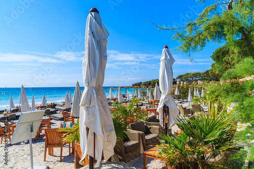 Umbrellas with sunbeds and cafe bar tables on Palombaggia beach, Corsica island, France