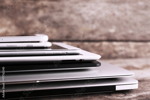 Pile of different modern electronics gadgets on old wooden background