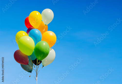 Colorful bunch of helium balloons isolated on background photo