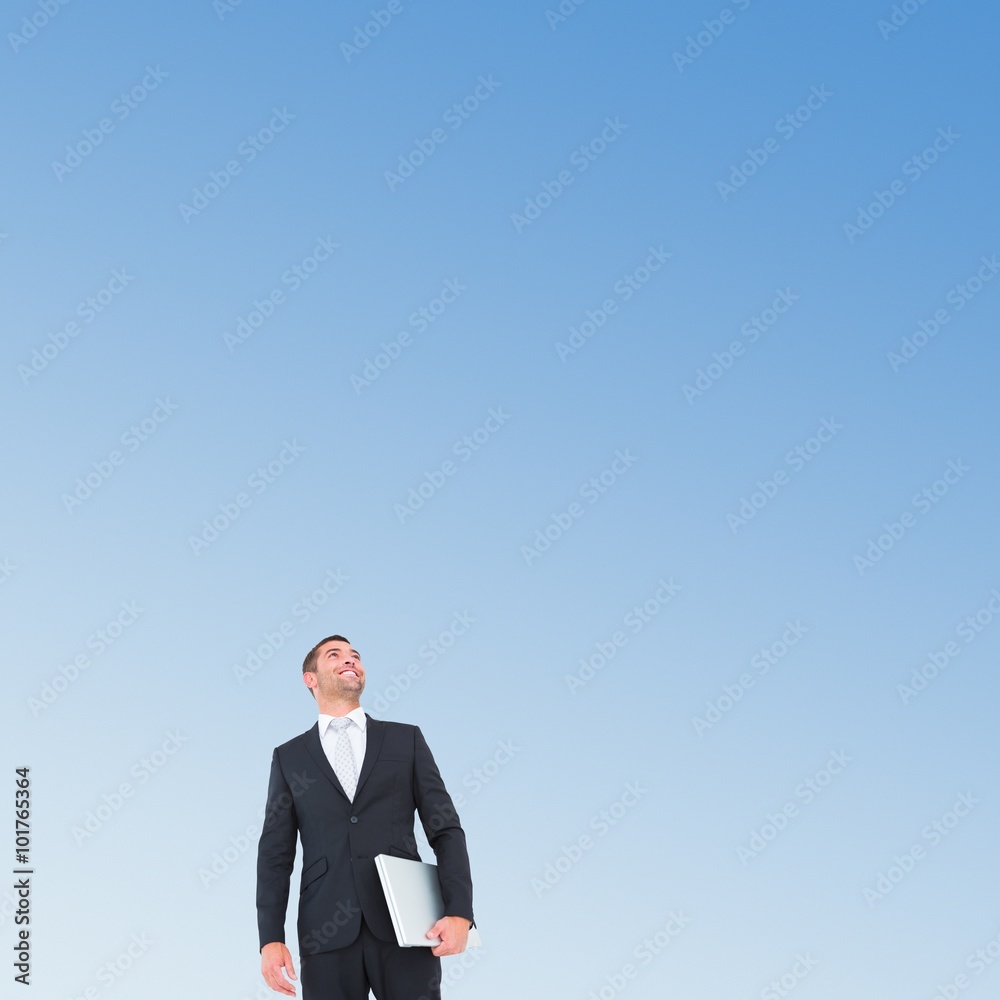 Composite image of businessman looking up holding laptop Composite image of businessman looking up holding laptop