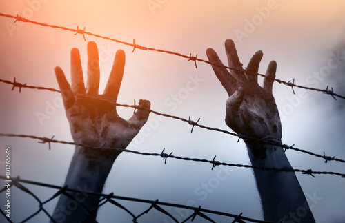 Refugee men and fence