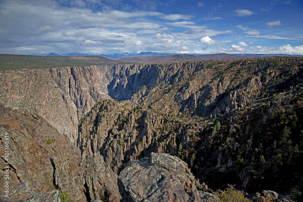 The Black Canyon of the Gunnison stretches out under a blue sky in Colorado, USA.