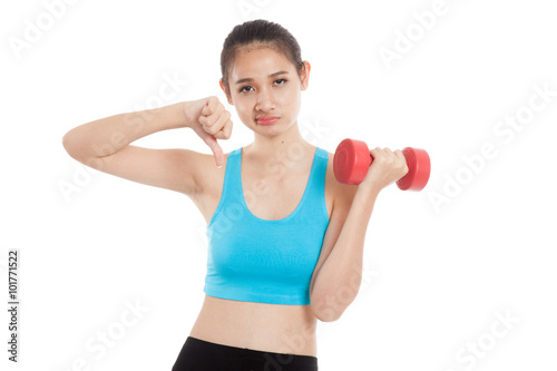 Beautiful Asian healthy girl thumbs down with dumbbell
