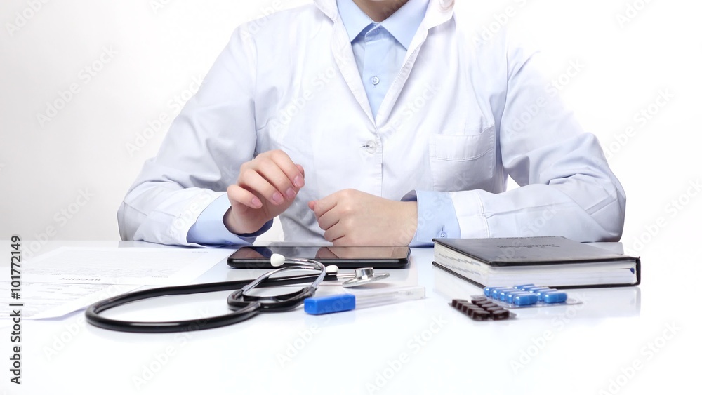 Doctor searching something on the tablet and writes, white Doctor searching something on the tablet and writes, white