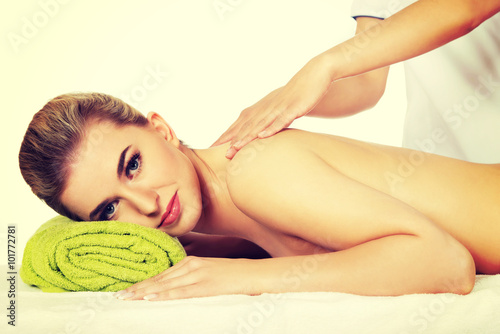 Young smile woman lying on a massage table and has massage.