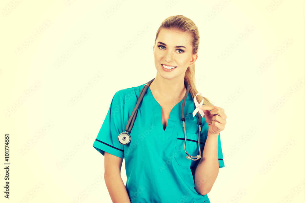 Smiling nurse holding pink breast cancer awareness ribbon Smiling nurse holding pink breast cancer awareness ribbon