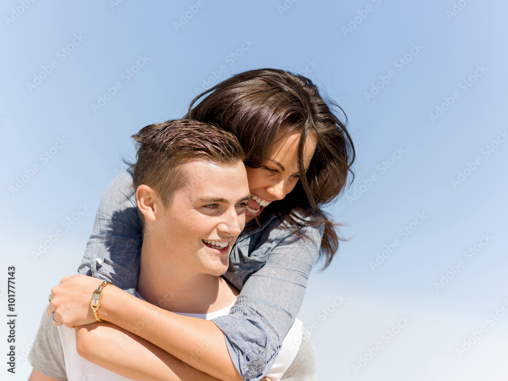 Portrait of man carrying girlfriend on his back