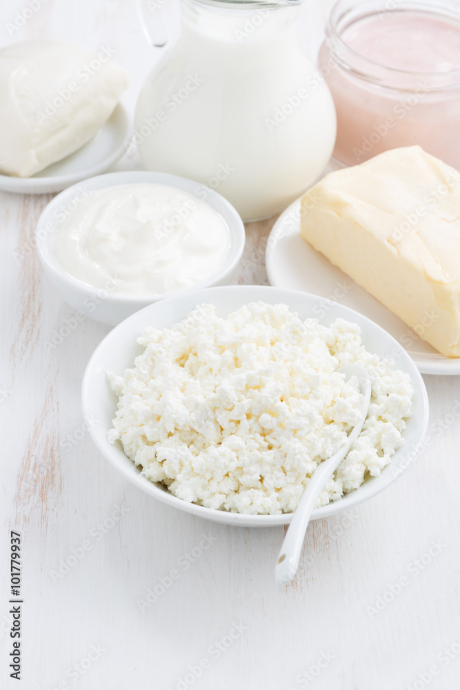 fresh dairy products on white wooden background, vertical