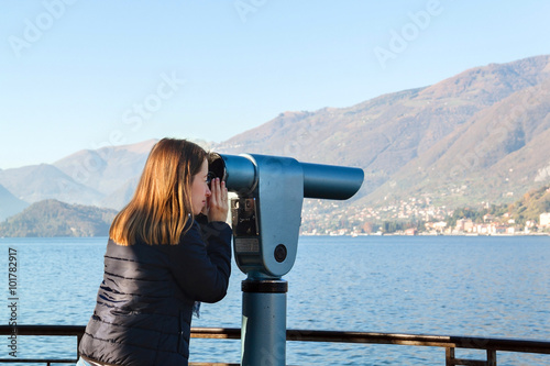 Young girl looking through a coin operated binoculars. Bellagio
