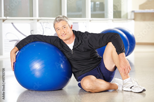 Senior mit Gymnastikball im Fitnesscenter