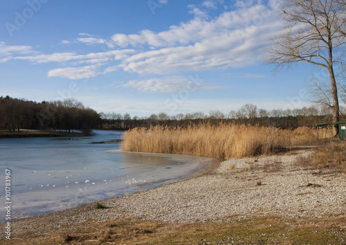 Winter scene in Bavaria - lake with ice melting on surface