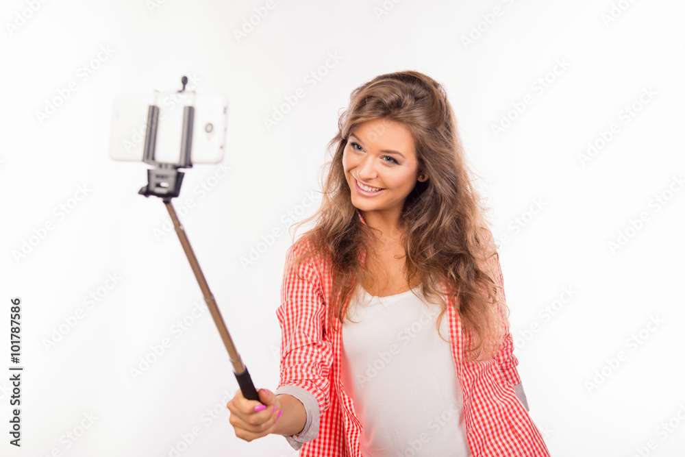 Happy nice-looking young woman making selfie photo with stick Happy nice-looking young woman making selfie photo with stick