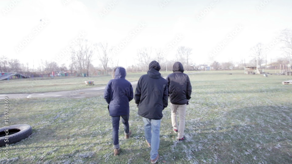 Three men go through grass Three men go through grass