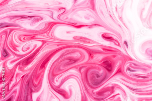 Red and white paint mixing into pink.