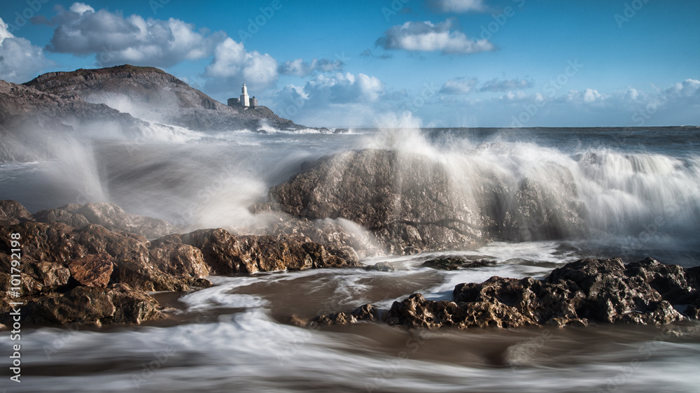 Crashing waves and Mumbles lighthouse on the Gower peninsula, South Wales.