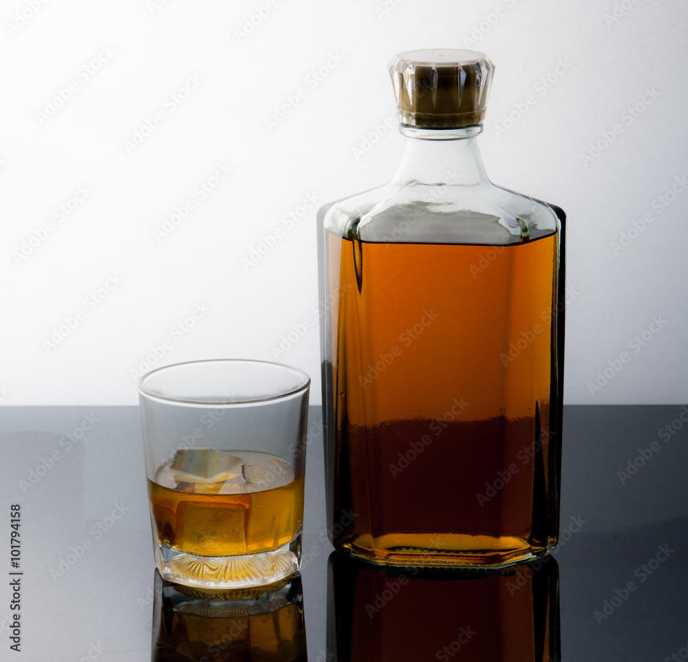 Glass and bottle with ice cubes and reflection drink alcohol on Glass and bottle with ice cubes and reflection drink alcohol on