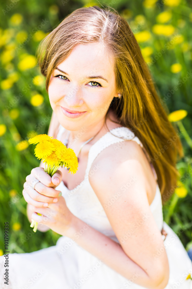 Portrait of beautiful girl with bouquet of yellow dandelions outdoor in summer, focus on eyes Portrait of beautiful girl with bouquet of yellow dandelions outdoor in summer, focus on eyes