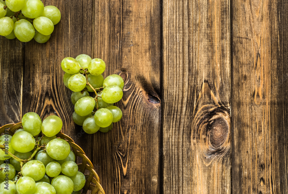 Φωτογραφία Bunch of green grapes in the basket on wooden background