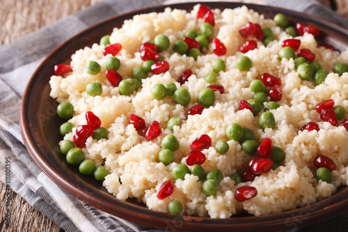 couscous with green peas and pomegranate close-up. Horizontal
