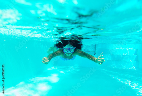 Underwater picture: woman swimming with mask and blue bikini in swimming pool.