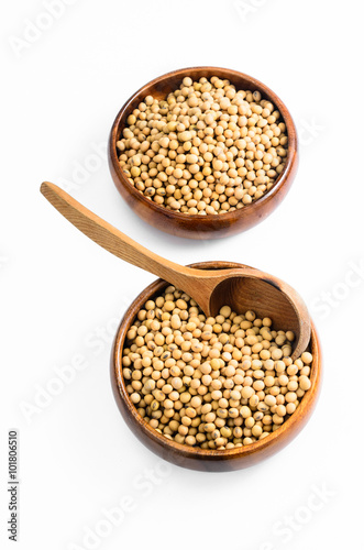 soybeans in wooden bowl with wooden spoon isolated on white background..
