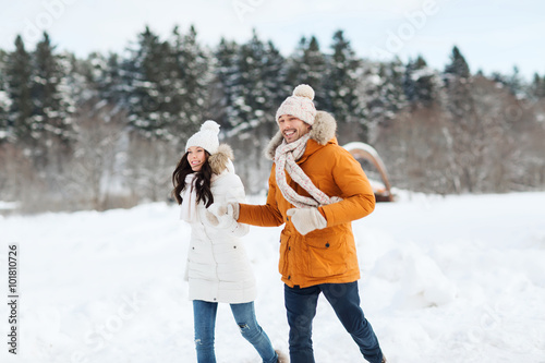 happy couple running over winter background