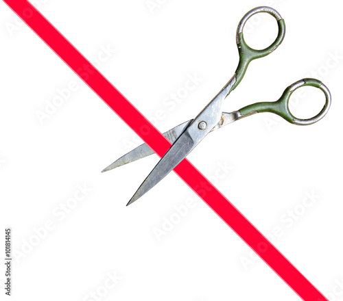 Scissors cut the red ribbon on a white background