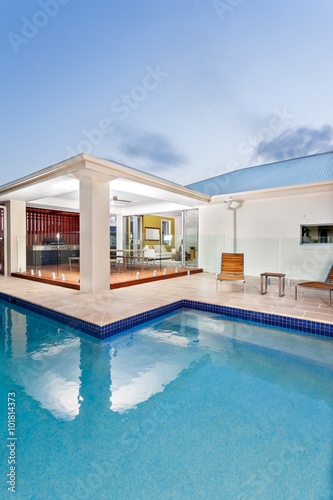 Modern swimming poll in the night with a luxury mansion or hotel © JRstock