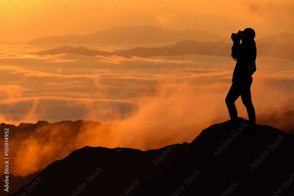 Silhouette of women is taking some photograph on mountain at sun