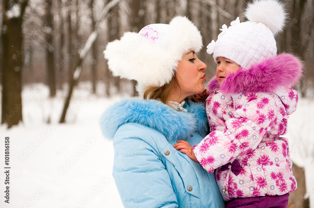 Mother and her little daughter enjoying beautiful winter day out