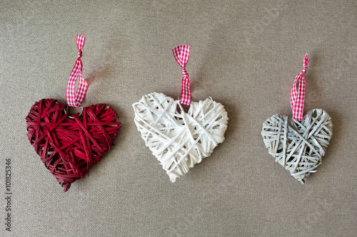 Three wooden heart shapes on linen fabric.