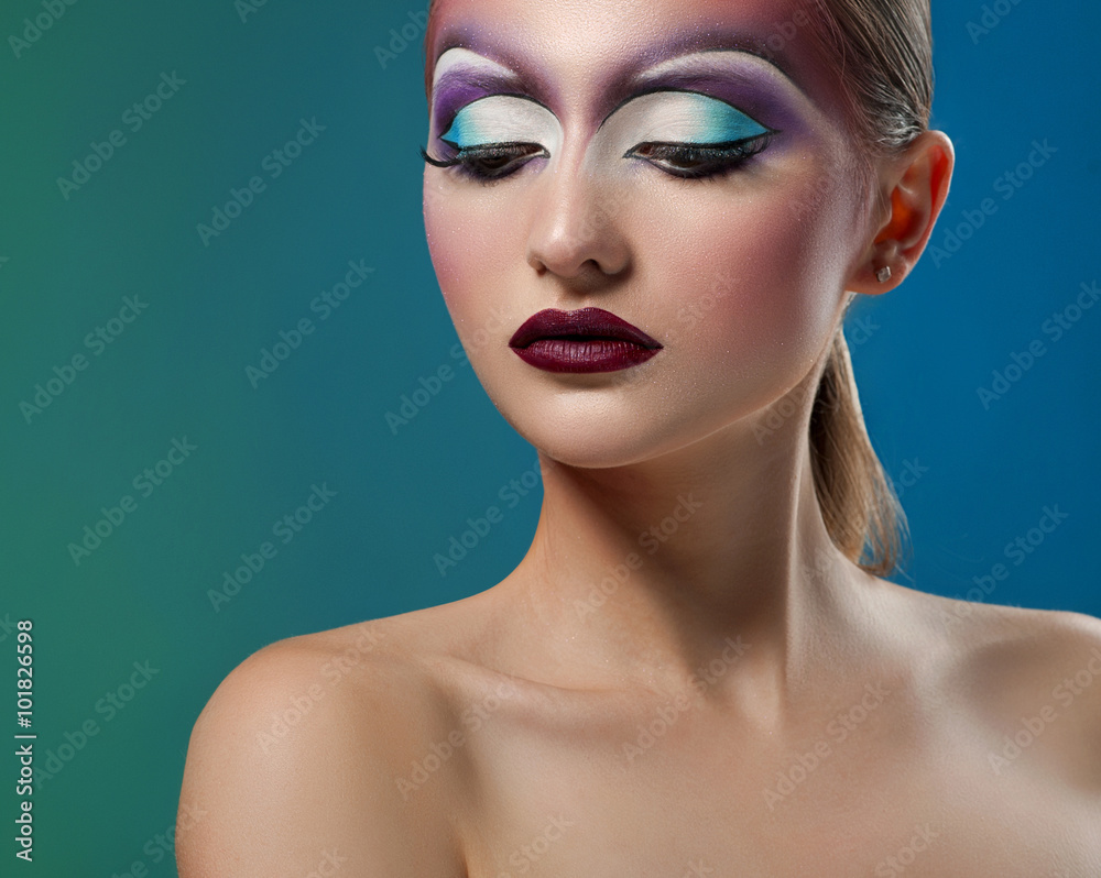 Inspired by nature. Horizontal portrait of a female model posing with colorful artistic makeup looking down copyspace on the side Inspired by nature. Horizontal portrait of a female model posing with colorful artistic makeup looking down copyspace on the side