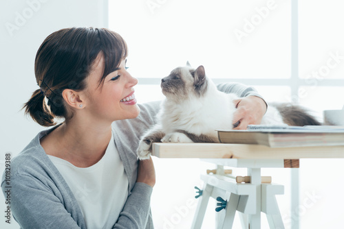 Happy woman cuddling her cat photo