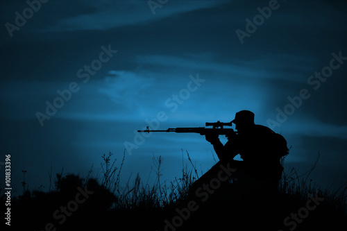 Konstfotografi Silhouette of military sniper with weapons at night.