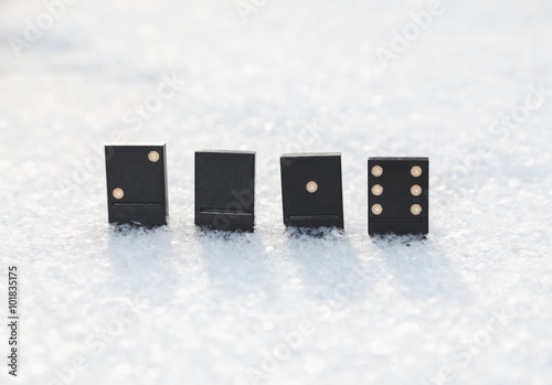 Dominoes standing in snow. It value of 2016