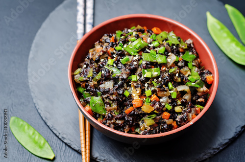 Black rice with snap peas and vegetables on a black