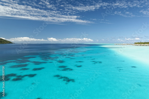 Amazing blue and turquoise lagoon/Lagoon in French Polynesia with a resort in the background in Tahaa island near Bora Bora