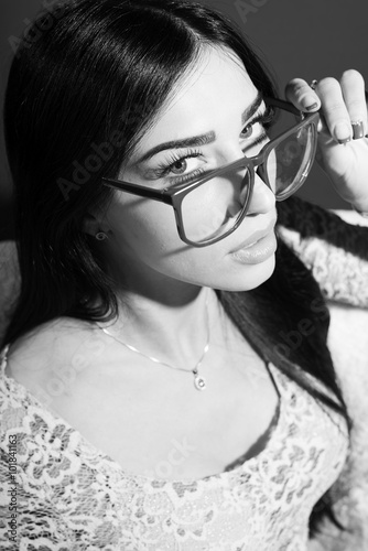 Black and white photography closeup of young pretty lady in glasses