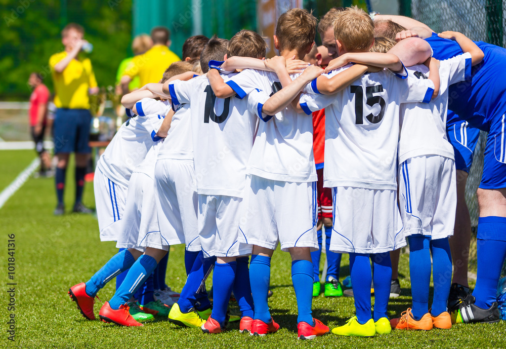 Coach giving young soccer team instructions. Youth soccer team together