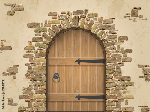 Arch of stone with closed wooden door. Entrance to the wine cellar.