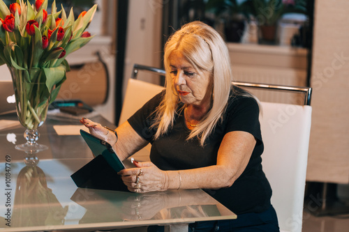 woman 65-70 years old using ipad tablet