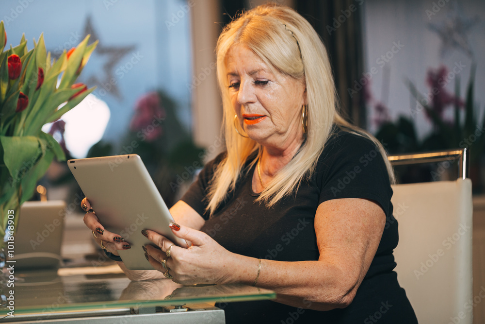 Fotografie woman 65-70 years old using ipad tablet