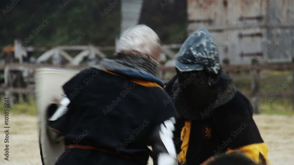 Two courageous knights attacking each other with swords, defending with shields Two courageous knights attacking each other with swords, defending with shields