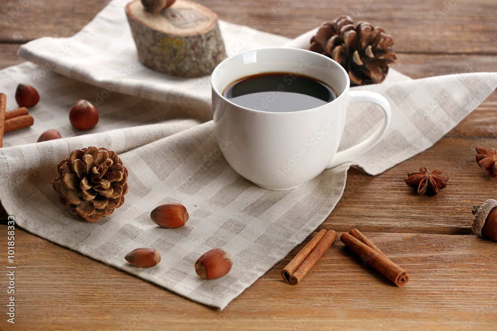 Fototapeta premium Cup of coffee on napkin on wooden background