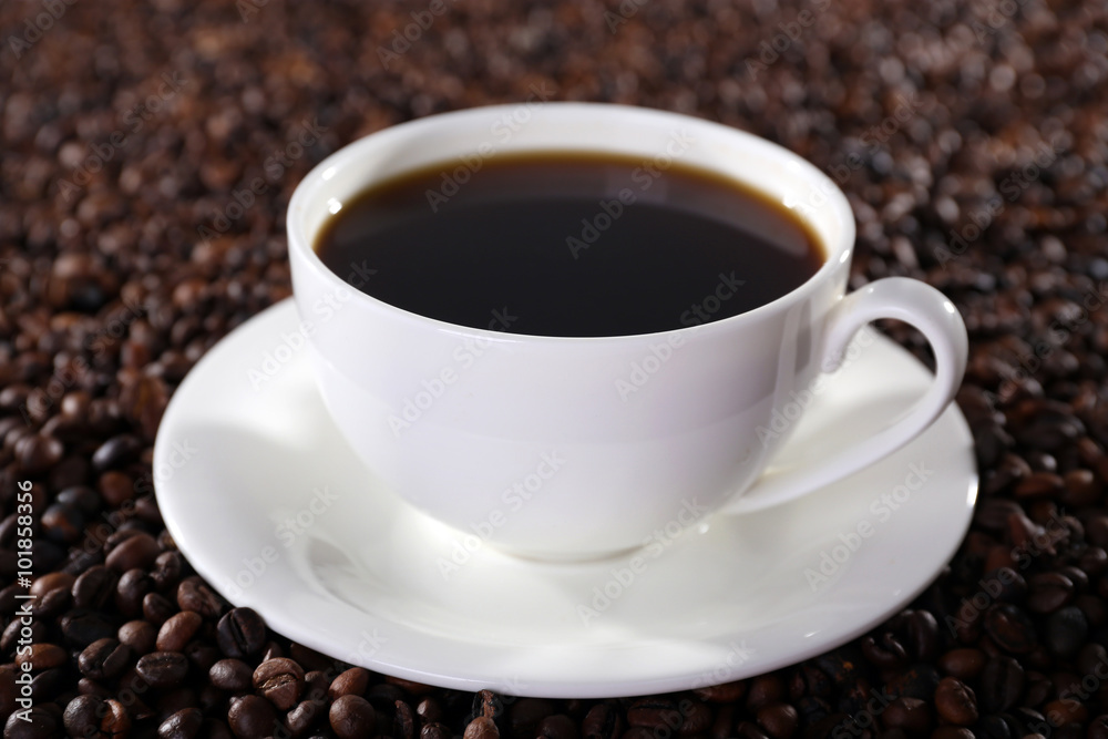 Cup of hot coffee on coffee beans background Cup of hot coffee on coffee beans background