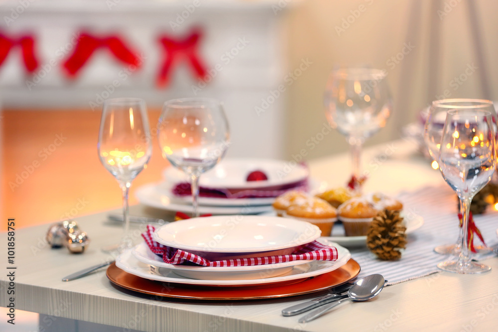 Christmas table setting with holiday decorations on fireplace background
