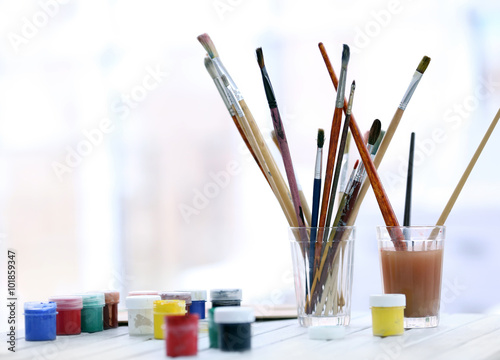 Drawing set with brushes and paints on white table